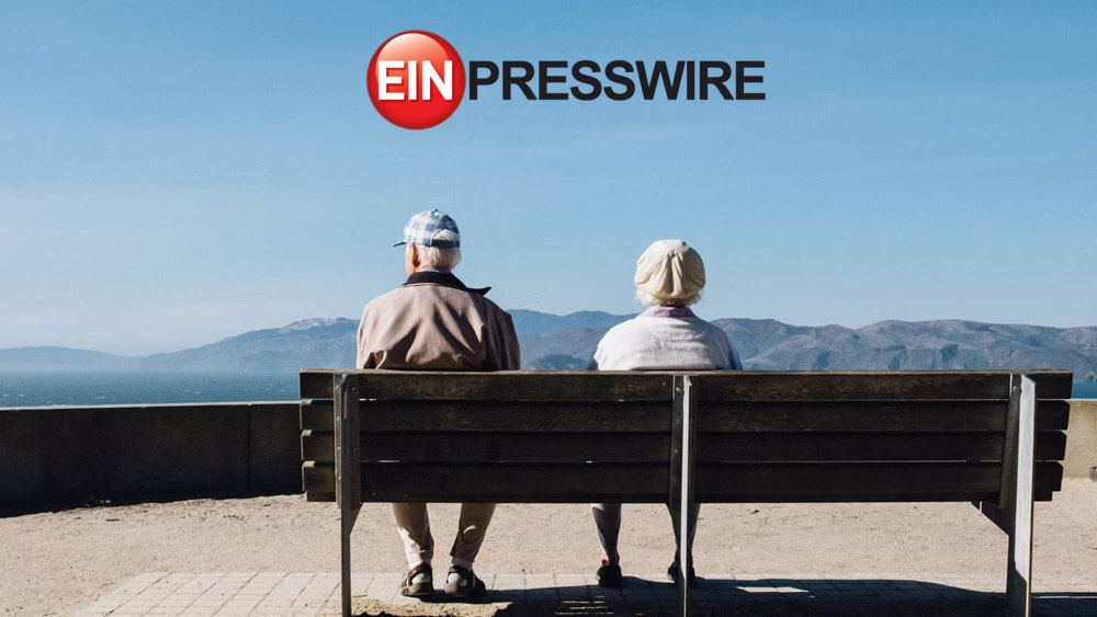 Elderly couple sitting on a bench looking over a lake