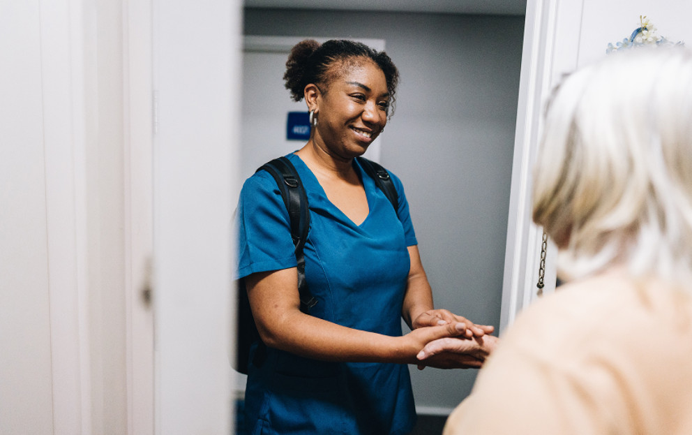 Caregiver holding elder's hand