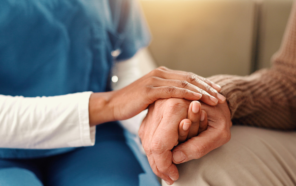 Caregiver holding elder's hand